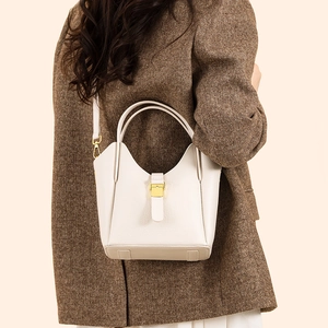 Vue macro détaillée du cuir blanc grainé et de la boucle en métal doré sur le sac seau