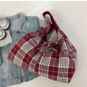 Retro red checkered tote bag with bow detail shown with headphones and tablet
