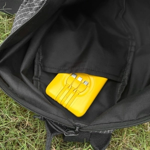 Vue interne montrant la poche de rangement d'un sac cabas à carreaux noir avec accessoires