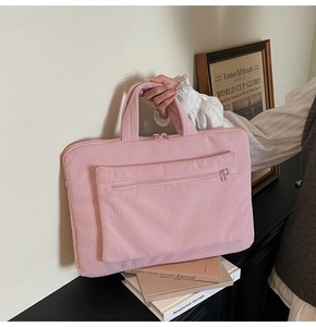 Macro view of pink corduroy laptop bag showing striped texture and zipper pocket