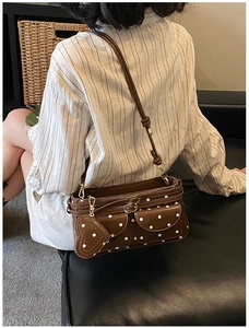 Detail der Retro-Umhängetasche mit Polka-Dots, Herzanhänger und kleinen Taschen