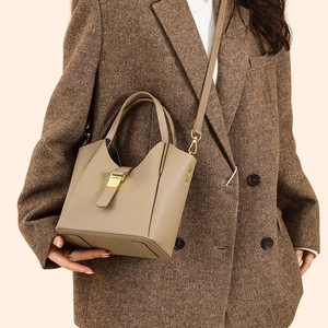 Détail du sac seau en cuir grainé avec boucles dorées et bandoulière amovible