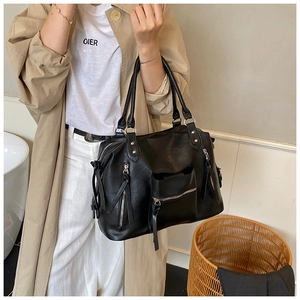 Detail view of black PU leather tote bag featuring multiple zippers and large capacity