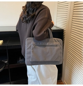 Detailed texture of grey corduroy laptop bag featuring durable metal zipper pocket
