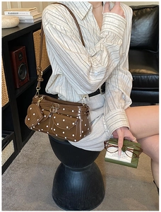 Detail der braunen Vintage-Schultertasche mit Polka Dots und Herzanhänger-Accessoire