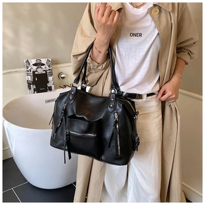 Detail of black large capacity PU leather shoulder bag with silver hardware and fringe tassels