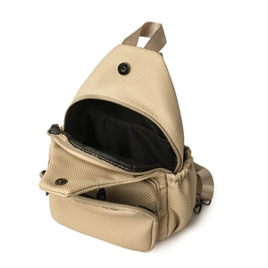 Vue détaillée d'un sac de poitrine en toile kaki montrant plusieurs compartiments de rangement