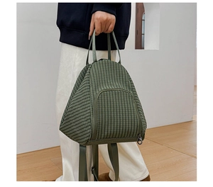 Detail view of a green checkered dumplings bag with nylon fabric and versatile straps