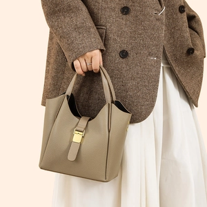 Gros plan du sac seau en cuir grainé kaki avec boucle dorée élégante et détails raffinés