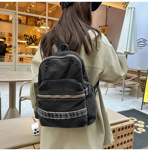 Vue arrière d'un mannequin portant un grand sac à dos en denim noir délavé stylé