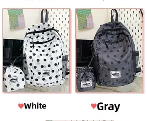 Detail view of large polka dot backpacks in white and grey colors with matching pouches