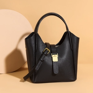 Détails du sac seau en cuir grainé noir avec boucle dorée et bandoulière ajustable