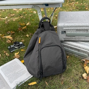 Sac fourre-tout en toile à carreaux noir et blanc sur herbe pour voyage en plein air