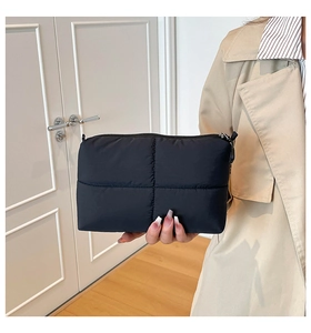 Close-up of black quilted cloud makeup bag with soft texture and metal zipper detail