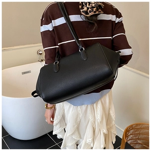 Dettaglio della borsa bowling in pelle martellata nera con grande capienza e texture