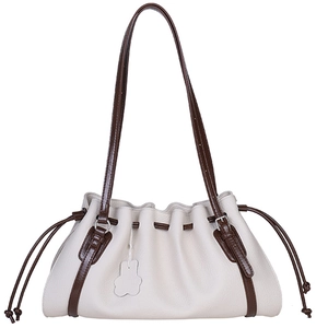 Beige pleated tote bag with dark brown straps and bear-shaped pendant on white backdrop