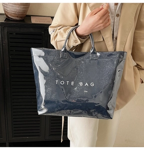 Glossy faux leather tote bag with white text print shown in a vintage interior setting