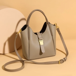 Détails de la texture grainée et de la boucle dorée sur un sac seau élégant et chic