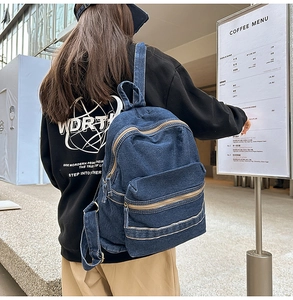 Gros plan d'un grand sac à dos en denim avec fermetures éclair et poches spacieuses en ville