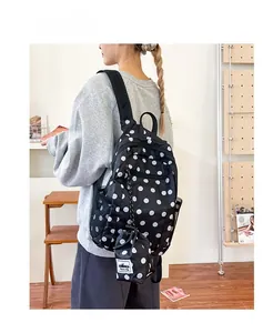 Close-up of black polka dot backpack with a matching mini drawstring pouch attachment