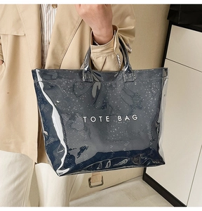 Detail of glossy transparent PVC tote bag with snake pattern inner and white text logo