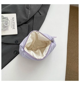 Close-up of soft quilted lavender makeup bag with zipper and beige interior lining