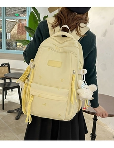 Detailed view of yellow school backpack with cute plush bunny and butterfly embroidery