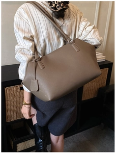 Gros plan du sac fourre-tout taupe montrant la texture cuir et la bandoulière longue