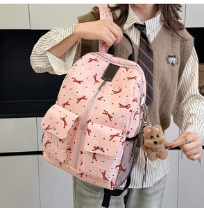 Détail du sac à dos rose à motifs nœuds avec texture plissée et pendentif chien peluche