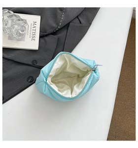 Detailed interior view of a light blue quilted cosmetic bag showing the spacious white lining