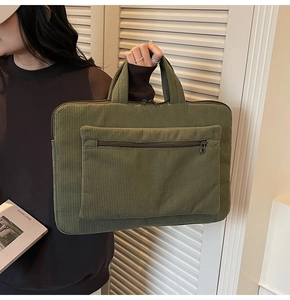 Detail of army green corduroy laptop bag with sturdy handles and front zipper pocket