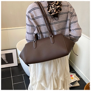 Dettaglio della borsa tote in pelle martellata marrone scuro con estensione laterale