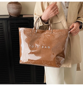 Detail of vintage brown snake-print tote bag with glossy PVC finish and top handle