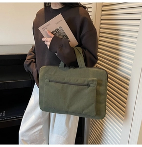Detail of olive green corduroy laptop bag showing fine ribbed texture and sturdy handles