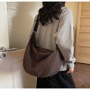Detalle de un bolso hobo grande de cuadros marrones con correa ajustable al hombro