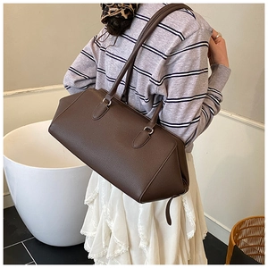 Dettaglio della borsa bowling in pelle marrone scuro con texture a grana fine