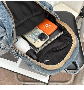 Vue détaillée du compartiment intérieur spacieux avec ordinateur portable dans le sac à dos denim