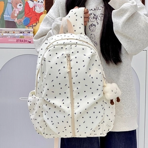 Close-up of a white starry school backpack with black stars and a cute cloud charm