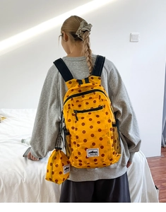 Detail of yellow polka dot backpack with matching mini coin purse and mesh side pocket