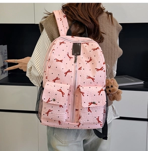 Vue arrière du sac à dos rose avec nœuds rouges, pois noirs et petit pendentif ours en peluche