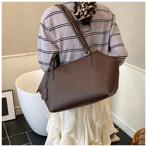 Deep brown pebble grain leather tote bag shown in use for a stylish commuter look