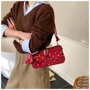 Schicke rote gepunktete Schultertasche mit Herzbeutel am Modell im Retro-Stil