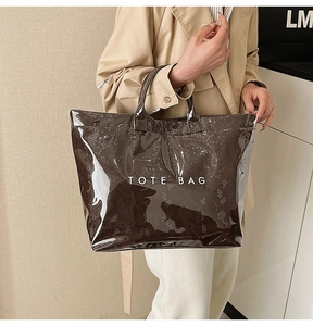 Detail of vintage brown snake print tote bag with glossy PVC finish and text