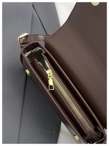 Detailed interior of vintage brown leather bag with golden zipper and fabric lining