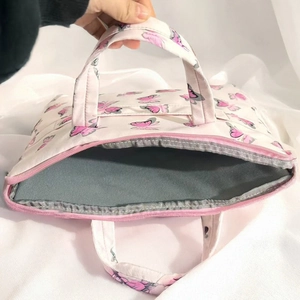 Detail view of the pink butterfly print bag showing the zip closure and padded lining