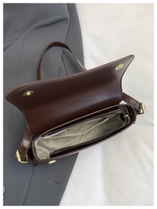 Internal view of brown faux leather bag with zipper pocket and metal buckle