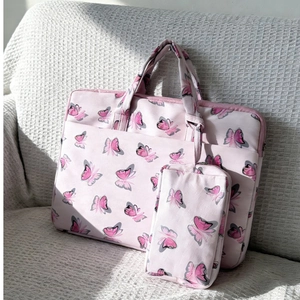 Detail view of pink floral shoulder bag with matching mini pouch on a waffle sofa