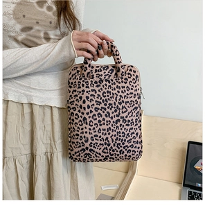 Detailed macro view of pink leopard print laptop bag with sturdy handles and zip closure
