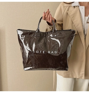 Detail of dark brown snakeskin embossed tote bag with white TOTE BAG text print
