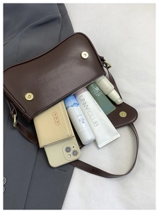 Internal view of dark brown leather crossbody bag showing capacity for phone and makeup